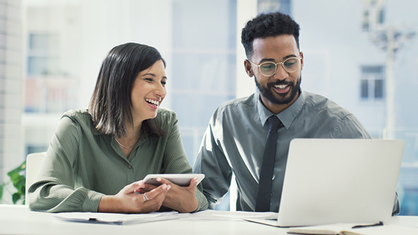 Female holding a tablet and male with a laptop